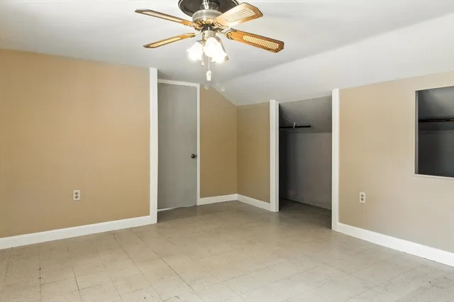 an empty room and chandelier fan