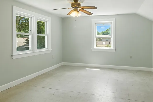 an empty room with a window and a fan