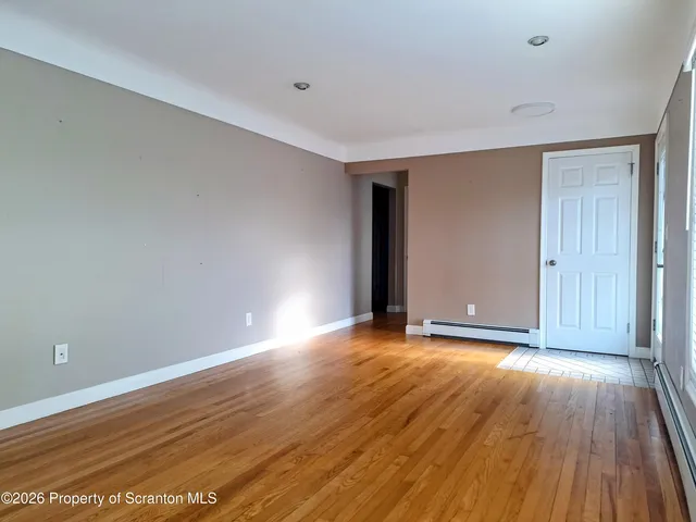 a view of an empty room with wooden floor