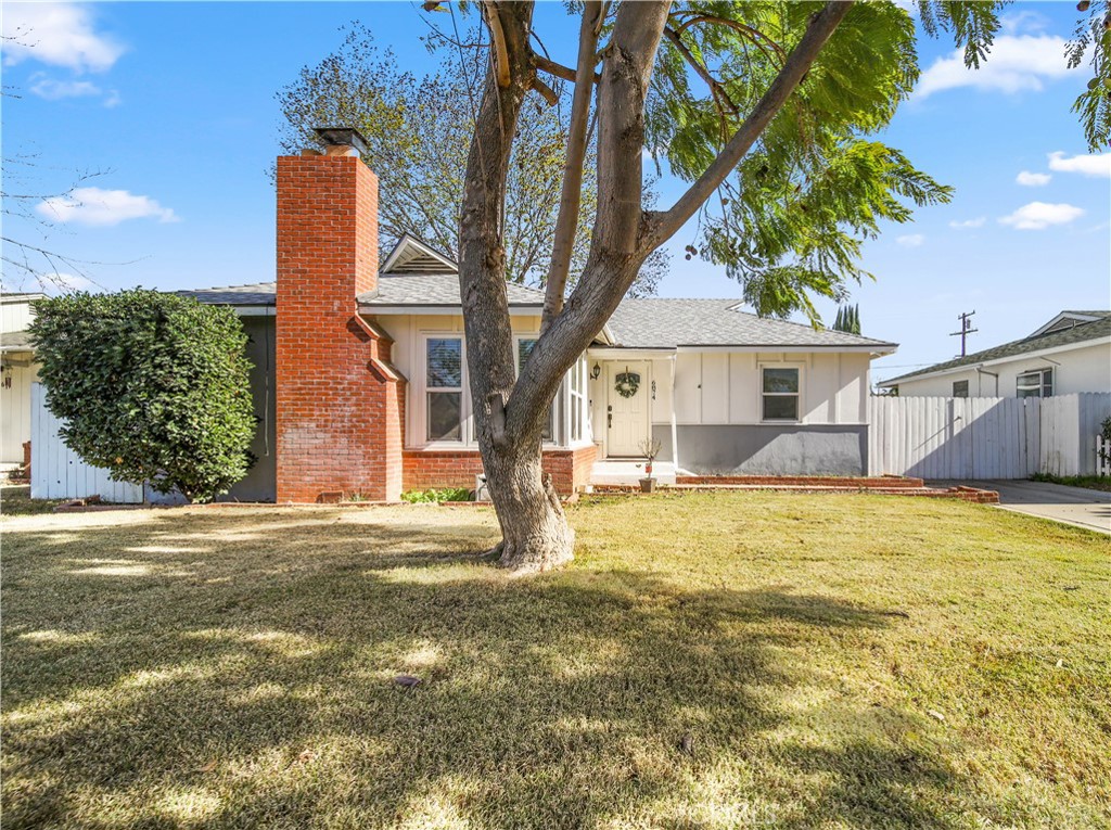 6874 Palomar Way Riverside, CA 92504 - Photo 1 of 1 a front view of a house with a garden and tree