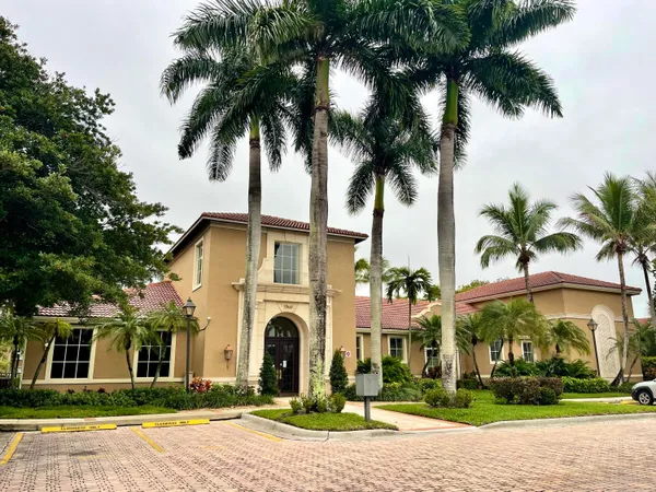 a front view of multi story residential apartment building with yard and parking