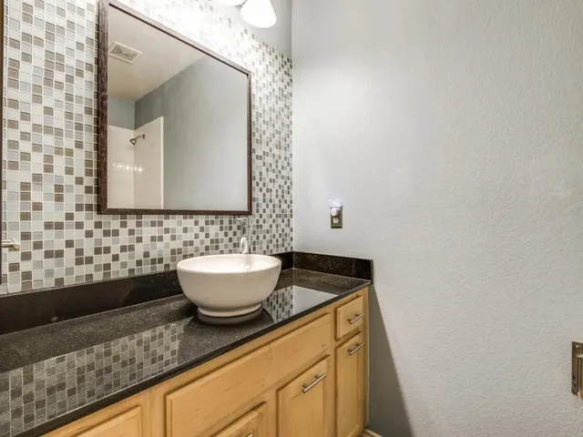 a bathroom with a granite countertop sink and a mirror