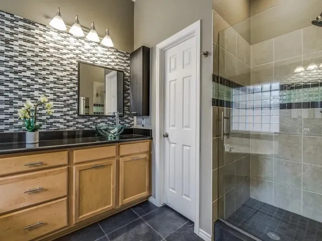 a bathroom with a shower sink and mirror