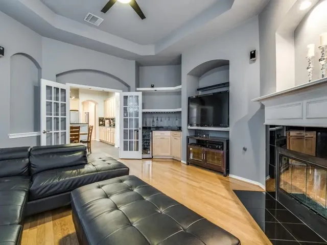 a large living room with stainless steel appliances furniture a fireplace and a flat screen tv