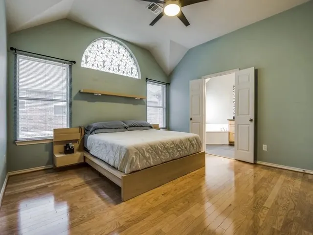 a spacious bedroom with a bed and a chandelier