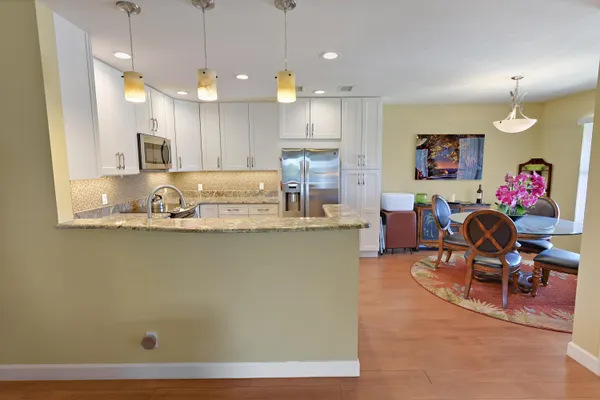 a living room with furniture kitchen view and a chandelier
