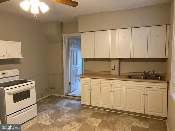 a kitchen with granite countertop white cabinets and white appliances