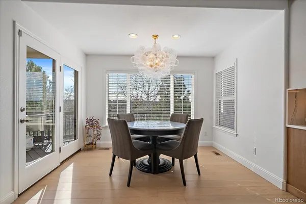 a room with a black white checkered floor with a gaming machine and dining chairs