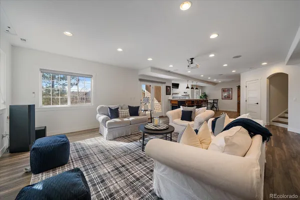 a living room with stainless steel appliances kitchen island granite countertop furniture wooden floor and a window