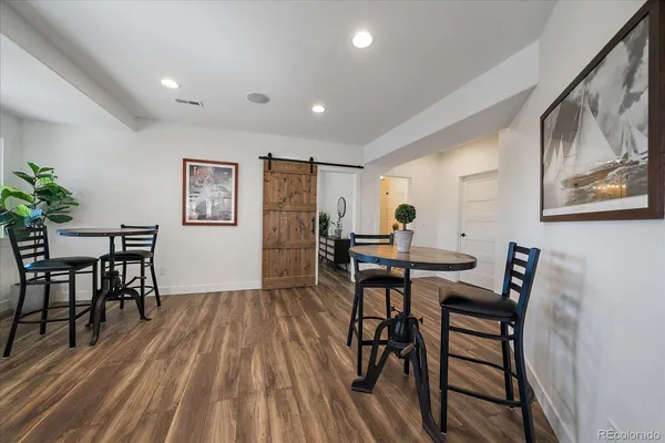 a living room with stainless steel appliances kitchen island granite countertop furniture a rug and wooden floor
