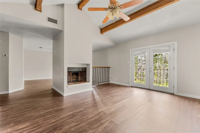 an empty room with windows and fireplace