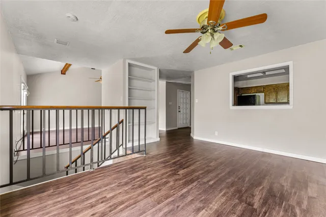 a view of a livingroom with wooden floor and a ceiling fan