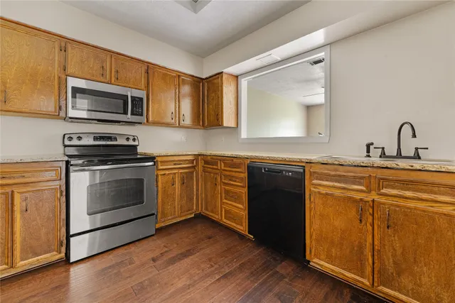 a kitchen with stainless steel appliances granite countertop a stove a sink and a microwave
