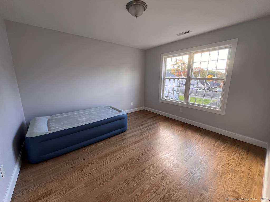 793 Pond Street Bridgeport, CT 06606 - Photo 14 of 28 an empty room with wooden floor and windows