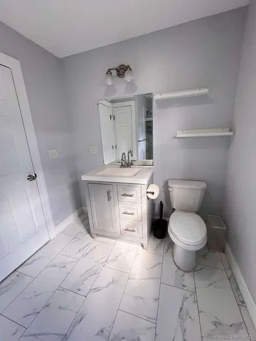 a bathroom with a toilet sink and cabinets
