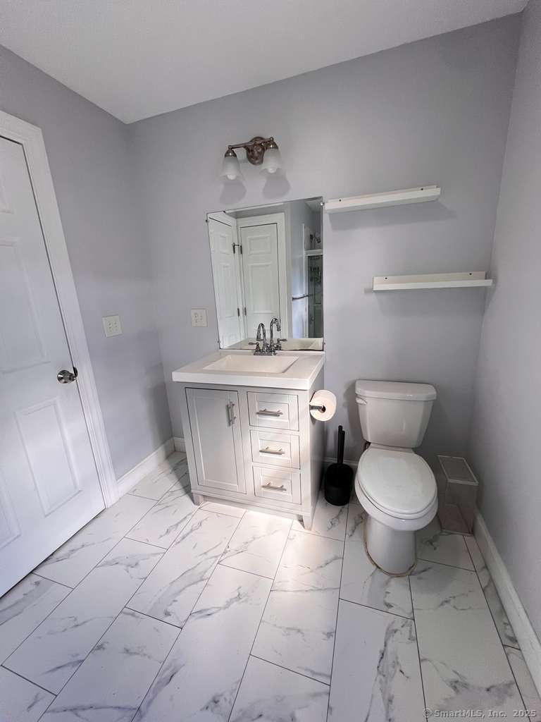793 Pond Street Bridgeport, CT 06606 - Photo 21 of 28 a bathroom with a toilet sink and cabinets