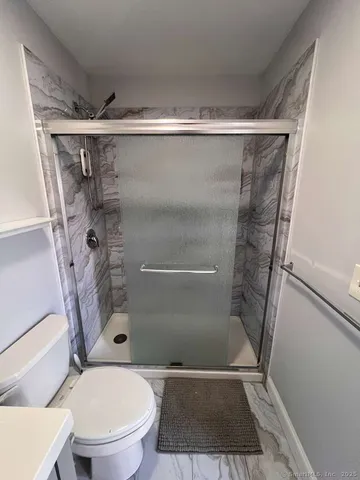 a bathroom with a toilet and a shower