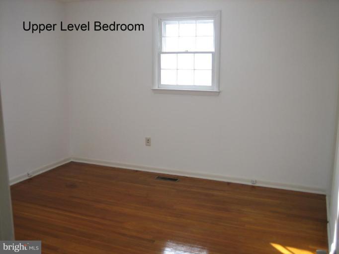 3918 Algiers Road Randallstown, MD 21133 - Photo 6 of 17 an empty room with wooden floor and windows