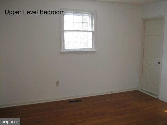 3918 Algiers Road Randallstown, MD 21133 - Photo 7 of 17 an empty room with wooden floor and windows