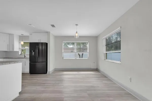 a kitchen with stainless steel appliances a refrigerator and wooden floor