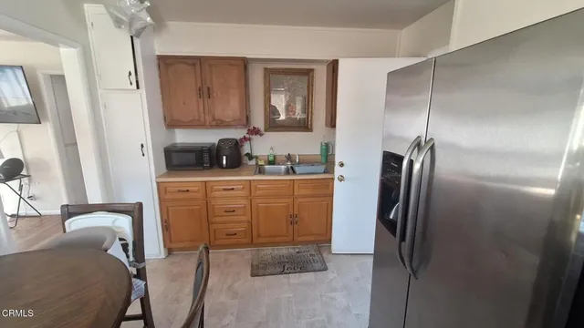 a kitchen with a refrigerator sink and cabinets