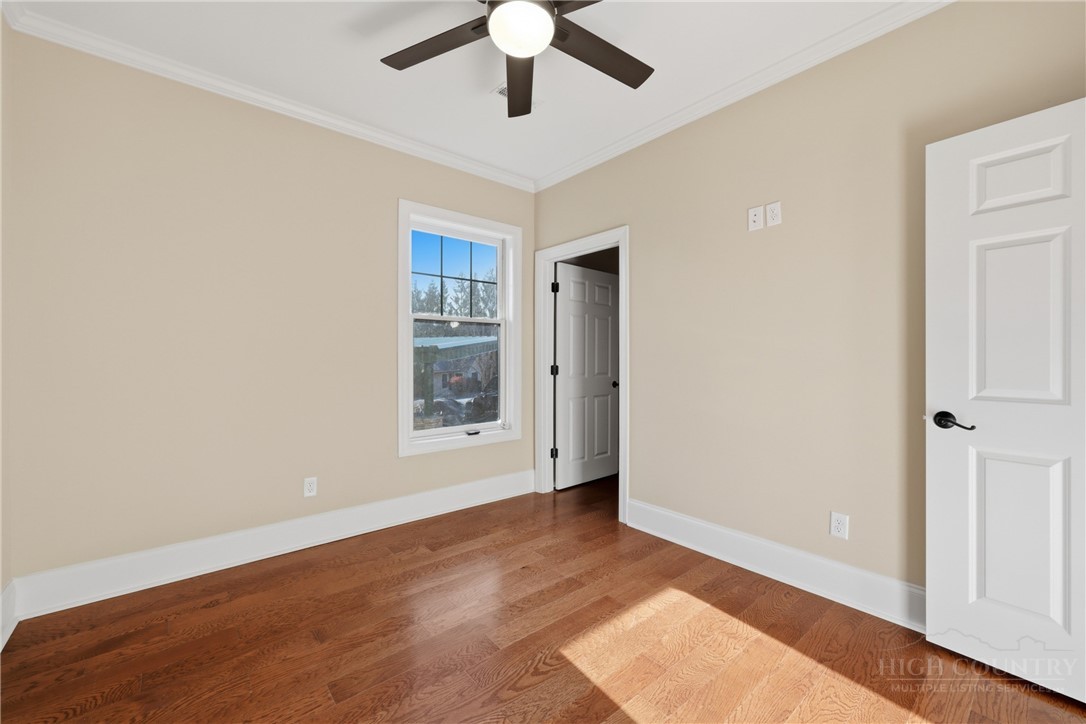 155 Gateway Drive, Unit 102 Boone, NC 28607 - Photo 15 of 43 an empty room with wooden floor chandelier fan and windows