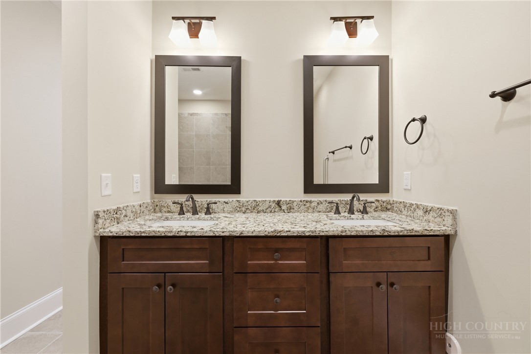 155 Gateway Drive, Unit 102 Boone, NC 28607 - Photo 26 of 43 a bathroom with a granite countertop sink and a mirror