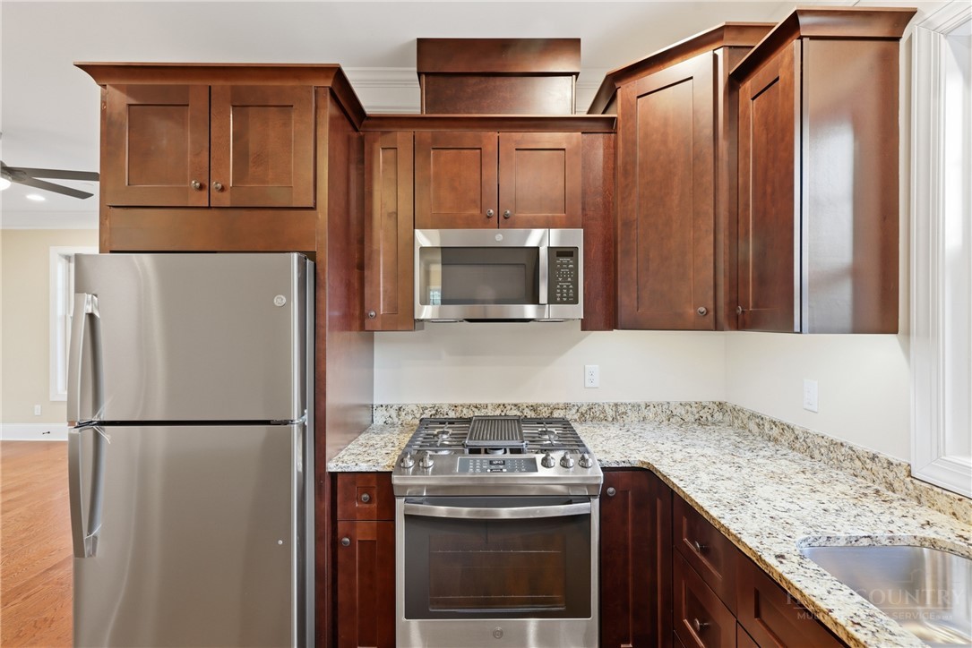 155 Gateway Drive, Unit 102 Boone, NC 28607 - Photo 9 of 43 a kitchen with granite countertop a refrigerator and a stove