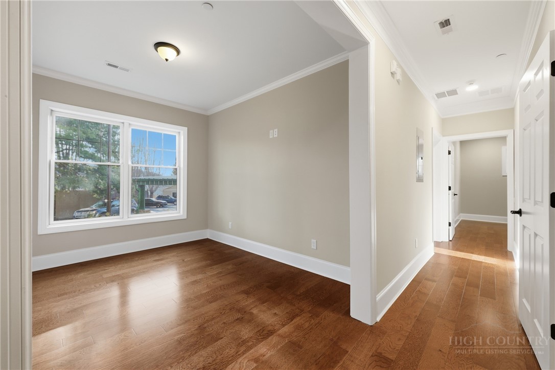 155 Gateway Drive, Unit 102 Boone, NC 28607 - Photo 10 of 43 a view of an empty room with wooden floor and a window