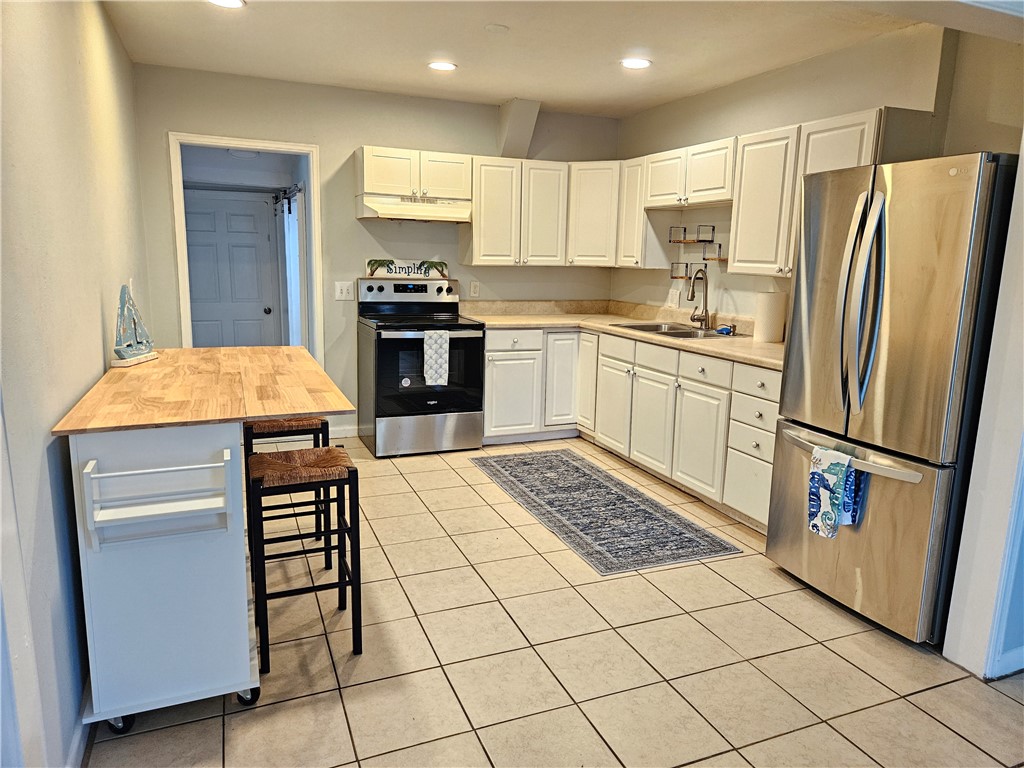 3716 Atlantic Boulevard Vero Beach, FL 32960 - Photo 6 of 22 a kitchen with stainless steel appliances a refrigerator sink and cabinets