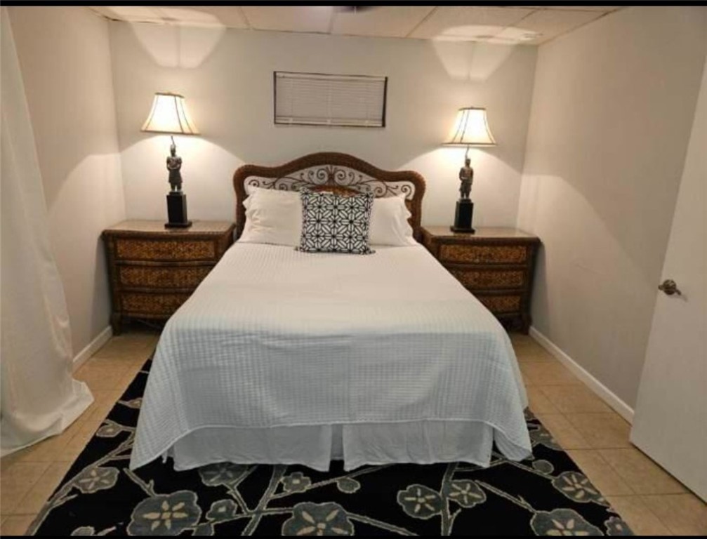 3716 Atlantic Boulevard Vero Beach, FL 32960 - Photo 8 of 22 a bedroom with a bed and a lamp