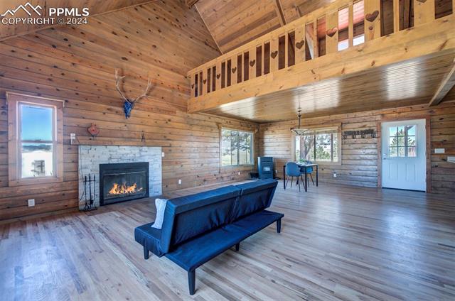 19350 Lemesany Road Calhan, CO 80808 - Photo 9 of 46 Living room featuring a fireplace, wood-type flooring, high vaulted ceiling, and wooden ceiling