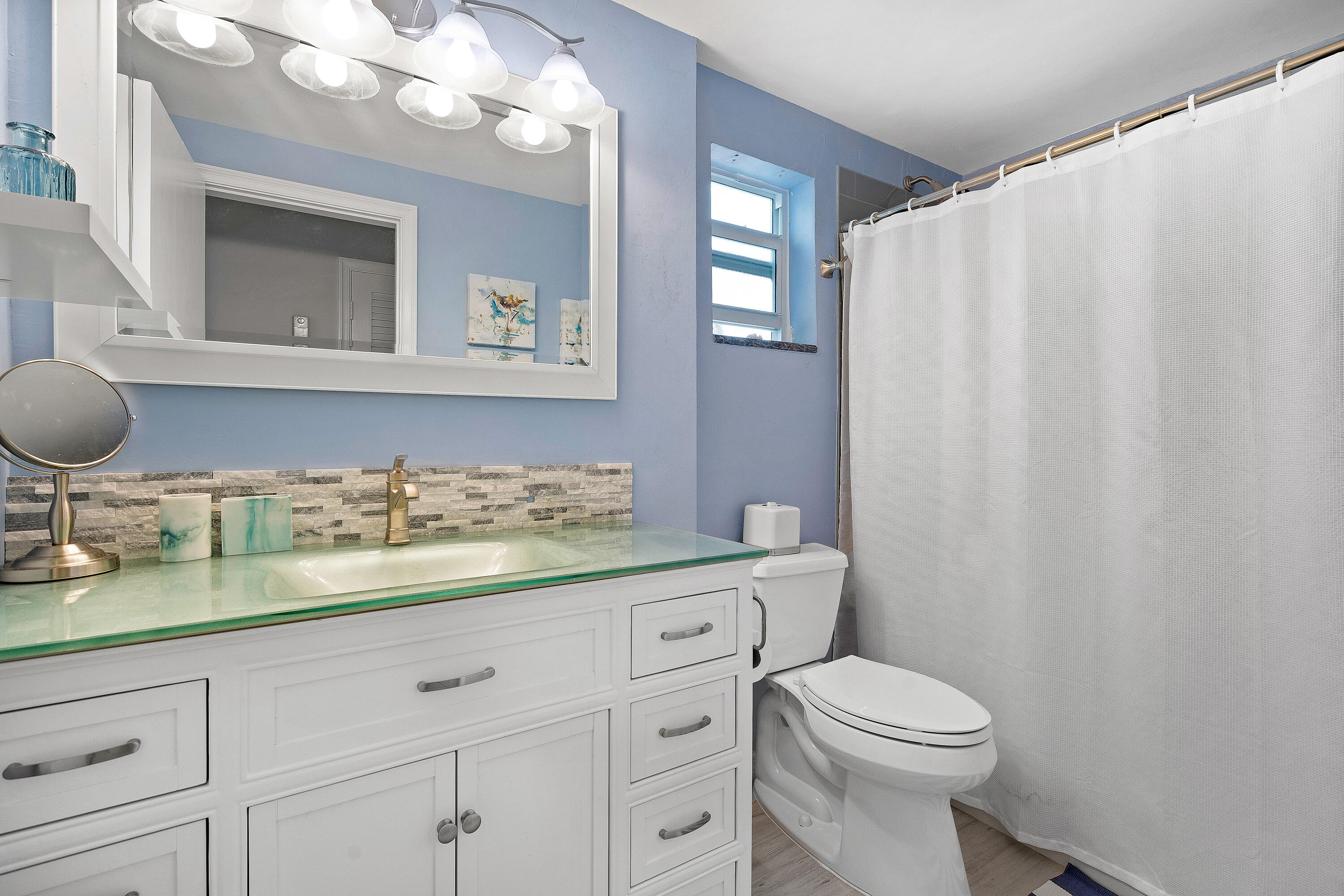 1030 Langer Way, Unit 5 Delray Beach, FL 33483 - Photo 11 of 21 a bathroom with a toilet a sink and mirror