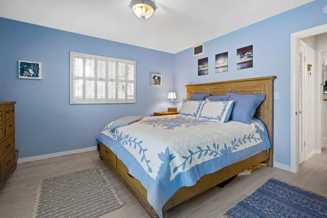 a large bed sitting in a bedroom next to a window