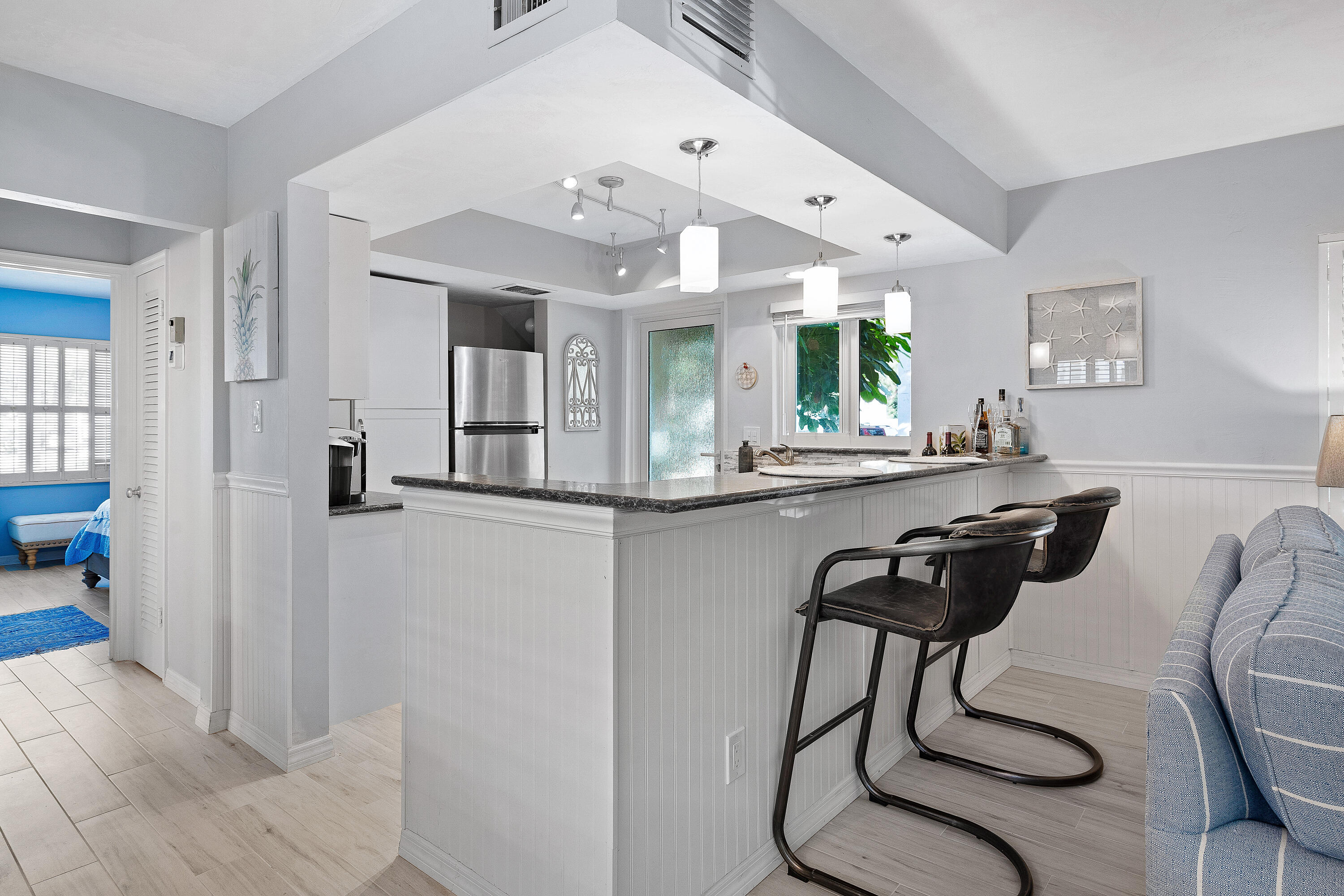 1030 Langer Way, Unit 5 Delray Beach, FL 33483 - Photo 2 of 21 a kitchen with stainless steel appliances kitchen island granite countertop a refrigerator a sink a dining table and chairs