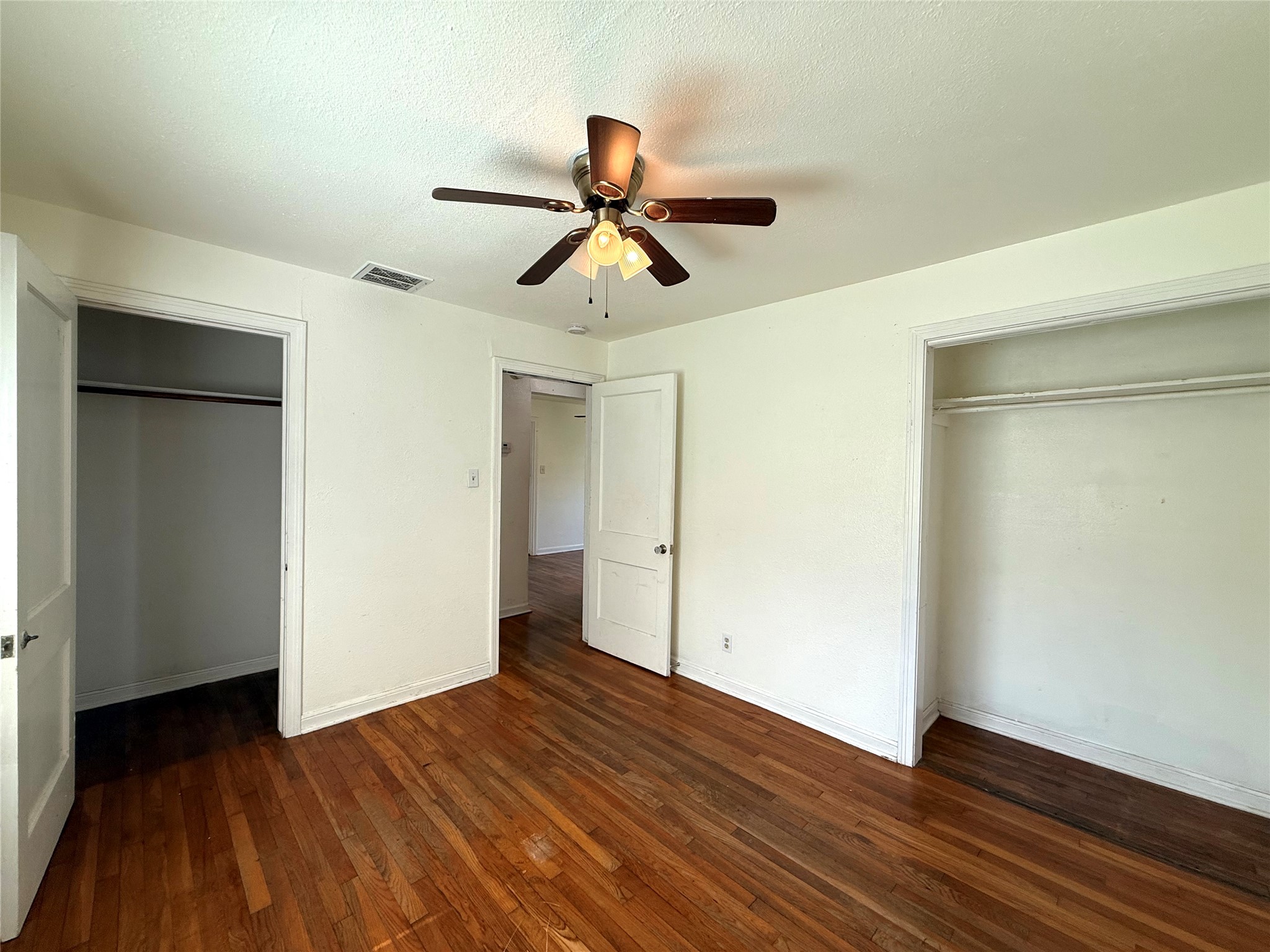 3305 Merrie Lynn Avenue Austin, TX 78722 - Photo 12 of 22 Hardwood floors and a ceiling fan create a comfortable atmosphere in this inviting bedroom.