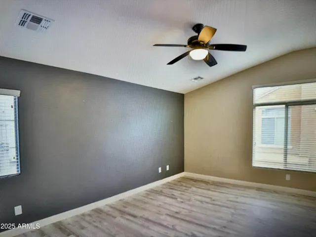 a view of empty room with window and wooden floor