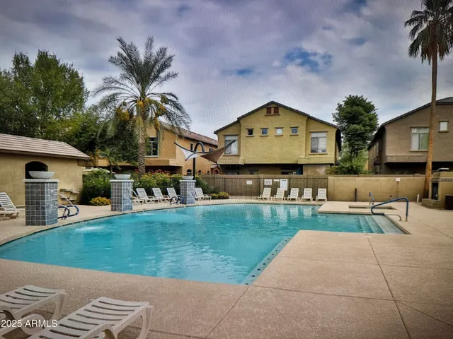 a view of a house with a swimming pool and a chairs in patio