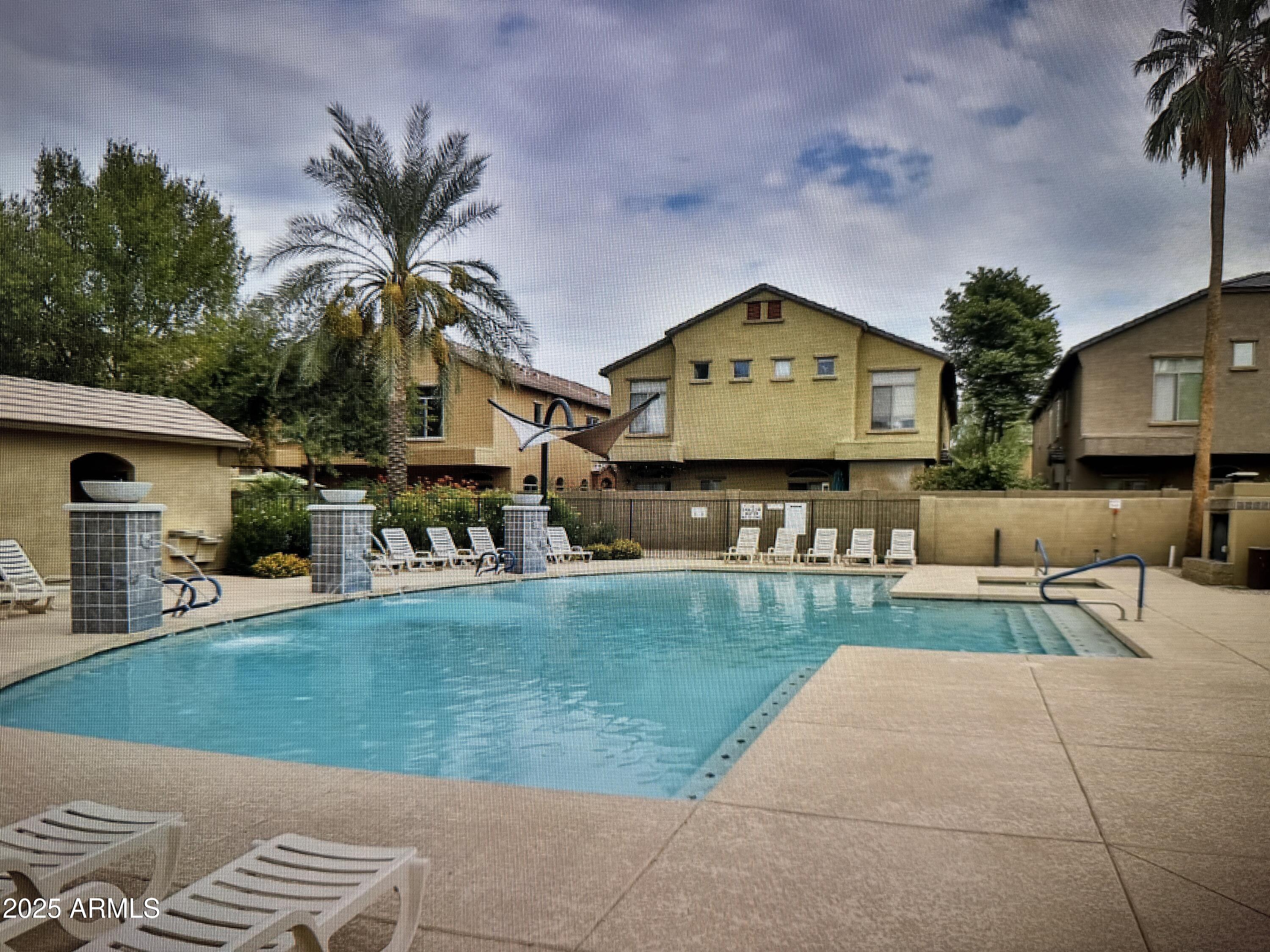 2150 West Alameda Road, Unit 1259 Phoenix, AZ 85085 - Photo 18 of 18 a view of a house with a swimming pool and a chairs in patio