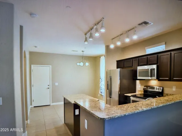 a kitchen with stainless steel appliances granite countertop a sink refrigerator and microwave