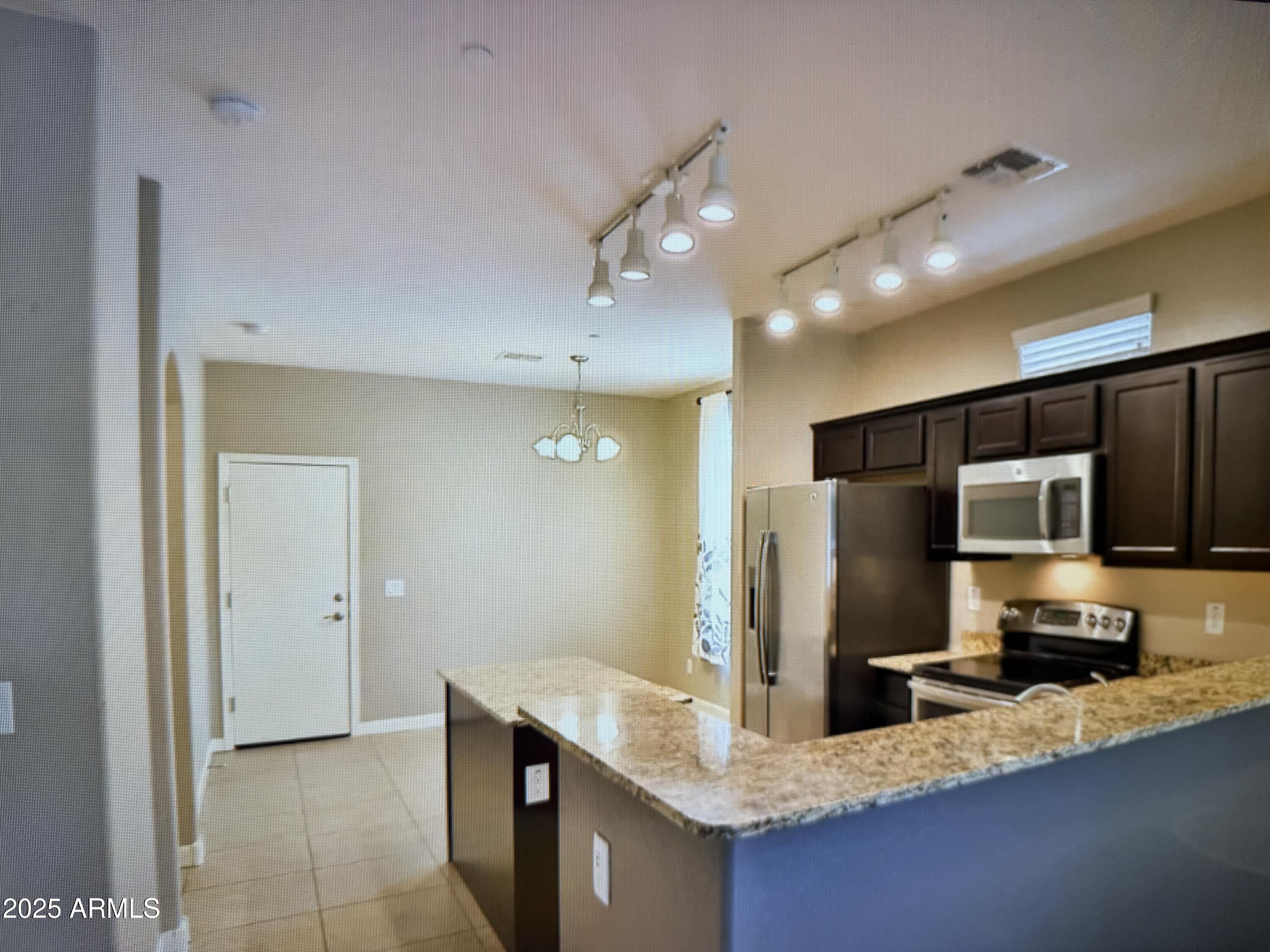 2150 West Alameda Road, Unit 1259 Phoenix, AZ 85085 - Photo 7 of 18 a kitchen with stainless steel appliances granite countertop a sink refrigerator and microwave