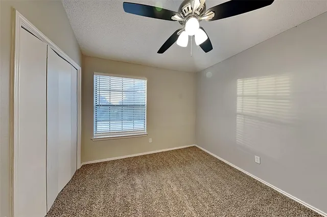 en empty room with windows and fan