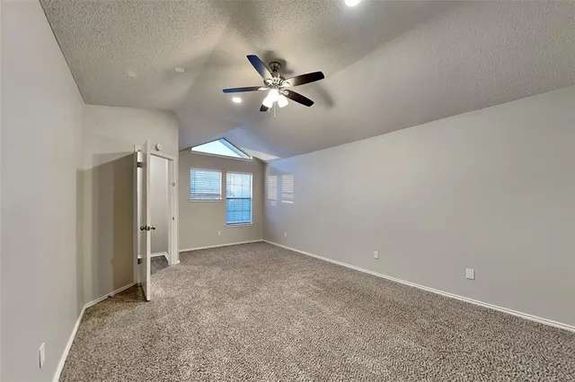 an empty room with closet and windows
