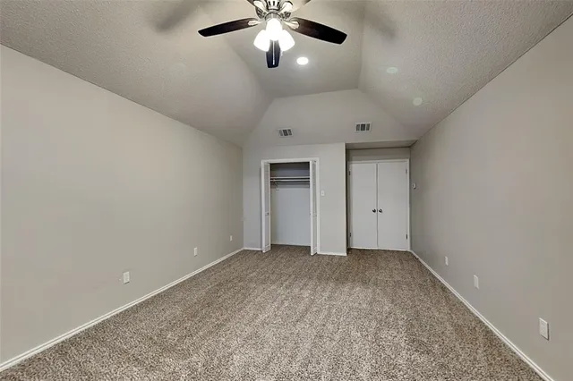 a view of an empty room with a chandelier fan