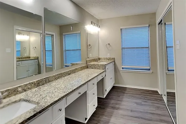 a bathroom with a granite countertop sink and a mirror