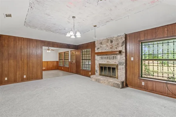 a view of an empty room with a fireplace and a window