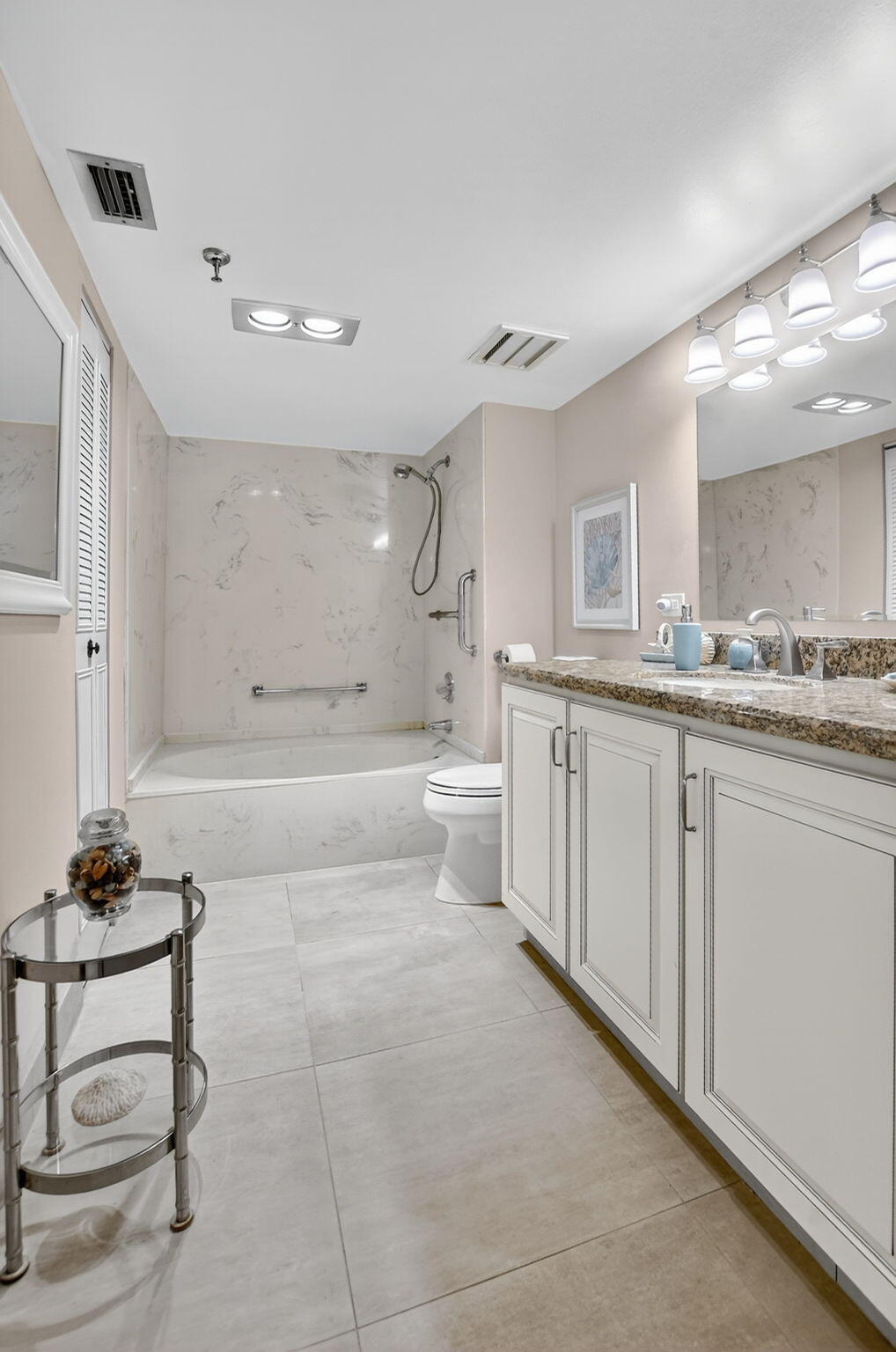 5340 Northwest 2nd Avenue, Unit 226 Boca Raton, FL 33487 - Photo 29 of 39 a spacious bathroom with a granite countertop sink a toilet a mirror and bathtub
