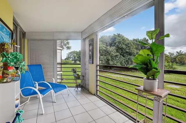 a view of a porch with chairs and potted plants