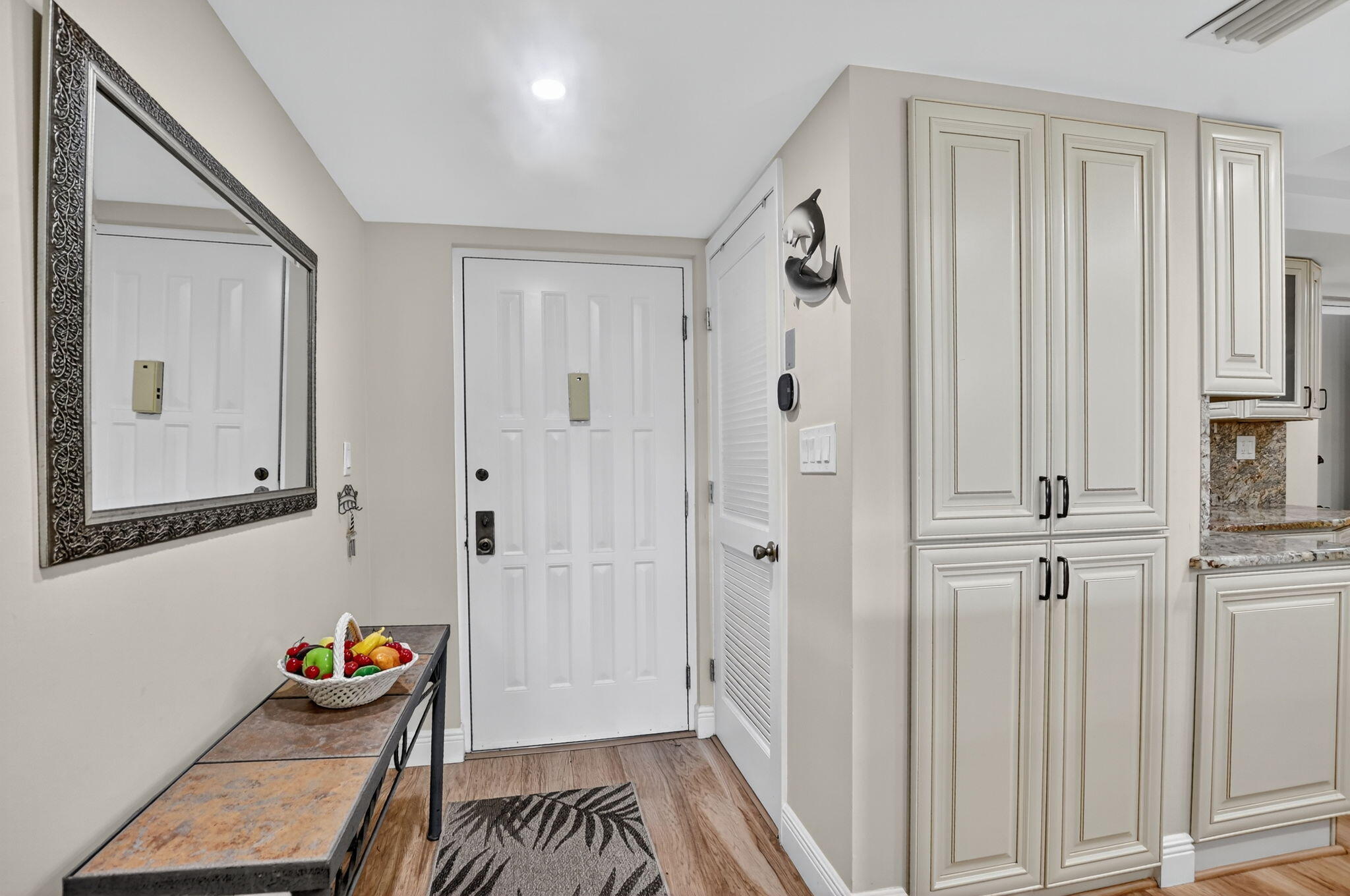 5340 Northwest 2nd Avenue, Unit 226 Boca Raton, FL 33487 - Photo 5 of 39 a hallway with front door wooden floor and furniture