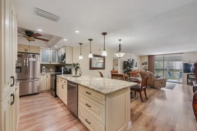 a kitchen with stainless steel appliances granite countertop a refrigerator stove and wooden floor